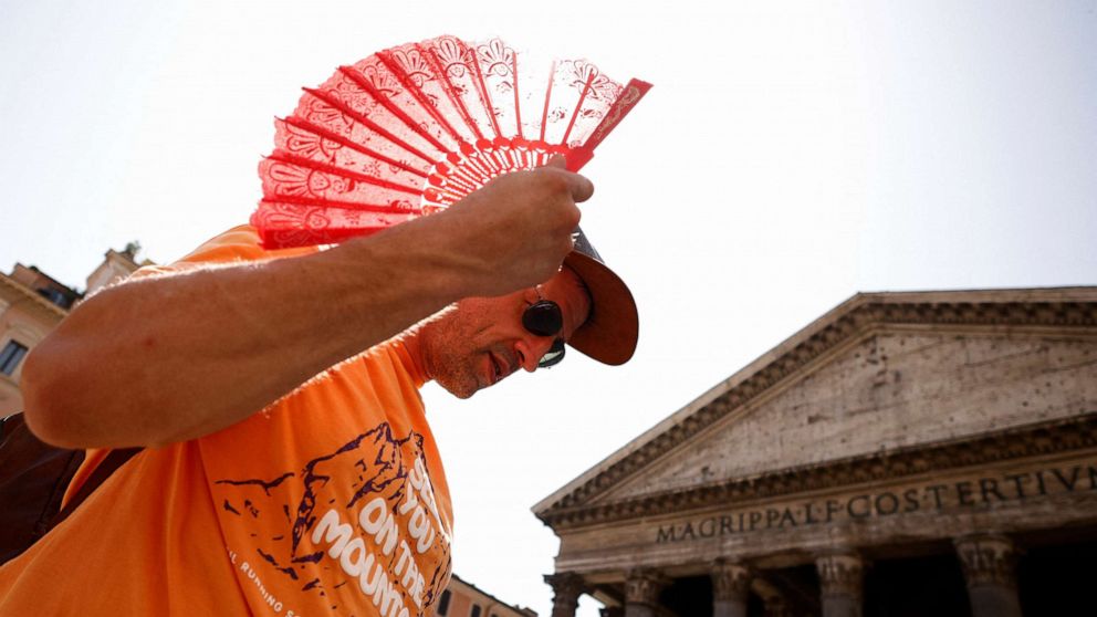 PHOTO: Florian Eberharter of Germany uses a fan to cool off while queuing to enter the Pantheon in Rome, Italy on July 19, 2023.