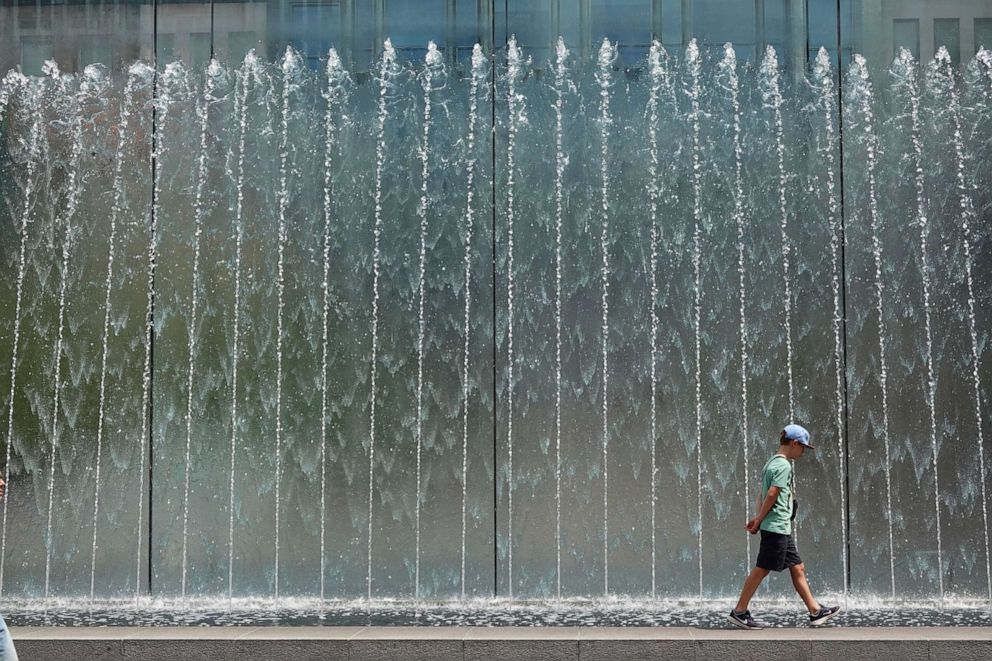 PHOTO: A boy walks on the edge of a fountain in Milan, Italy, July 19, 2023.
