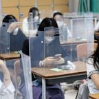 Senior students wait for class to begin with plastic barriers placed on their desks at Jeonmin High School in Daejeon, South Korea, May 20, 2020.