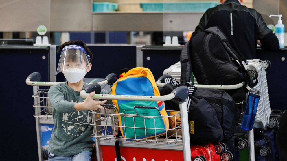 PHOTO: A child wearing a face mask looks on at the check-in counters of the Hong Kong International Airport amid the COVID-19 pandemic in Hong Kong, China, March 21, 2022.