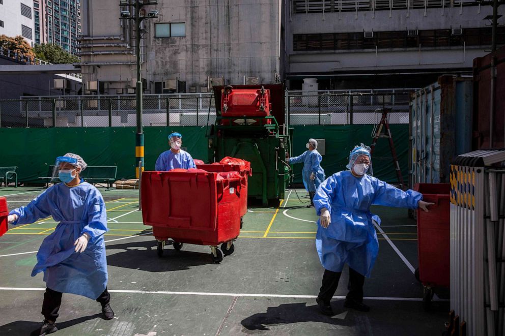 PHOTO: Hospital workers dispose medical waste outside Queen Elizabeth Hospital in Hong Kong on March 10, 2022, as the government announced the facility will be used only for COVID-19 patients.