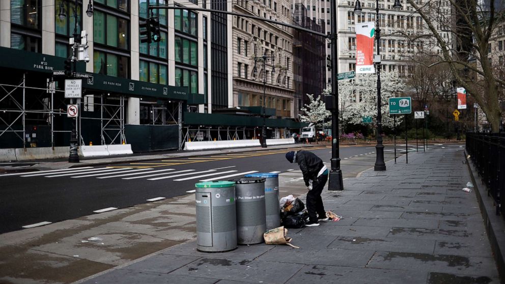 PHOTO: A homeless man sifts through trash on a nearly deserted street in lower Manhattan during the outbreak of the coronavirus disease in New York City, April 3, 2020.