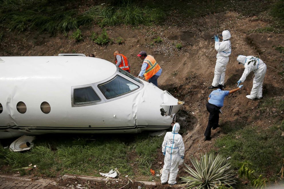 PHOTO: Forensic technicians and police officers from the Honduran National Police inspect the wreckage of a Gulfstream G200 aircraft that skidded off the runway during landing at Toncontin International Airport in Tegucigalpa, Honduras, May 22, 2018.