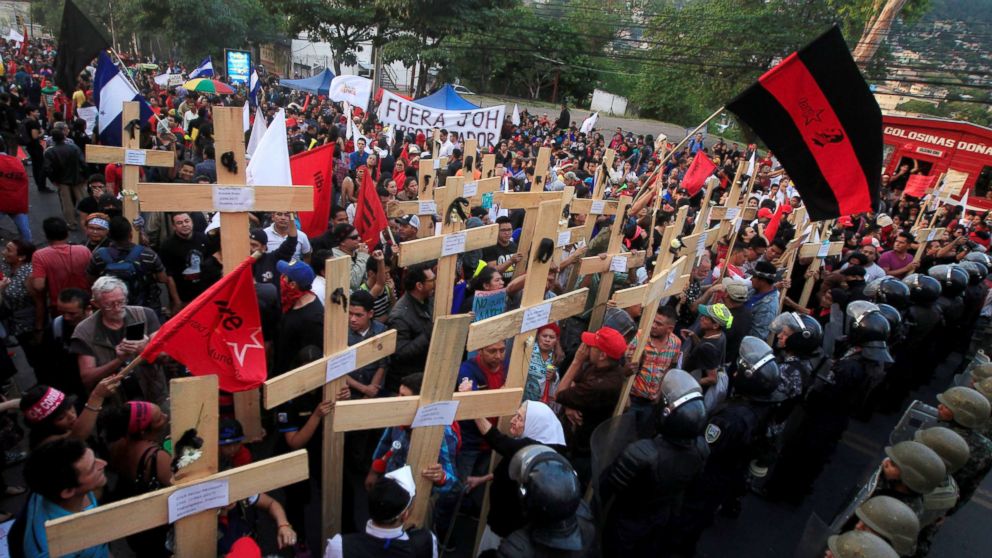PHOTO: Opposition supporters hold wooden crosses in front of security forces guarding the U.S. Embassy during a protest over a contested presidential election with allegations of electoral fraud in Tegucigalpa, Honduras, Dec. 21, 2017.