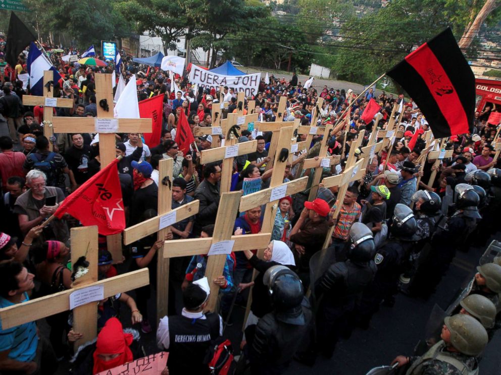 PHOTO: Opposition supporters hold wooden crosses in front of security forces guarding the U.S. Embassy during a protest over a contested presidential election with allegations of electoral fraud in Tegucigalpa, Honduras, Dec. 21, 2017.