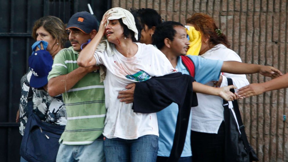 A wounded woman is taken away after violence broke out between soldiers and police against supporters of ousted Honduras' President Manuel Zelaya near the presidential residence in Tegucigalpa, June 29, 2009.