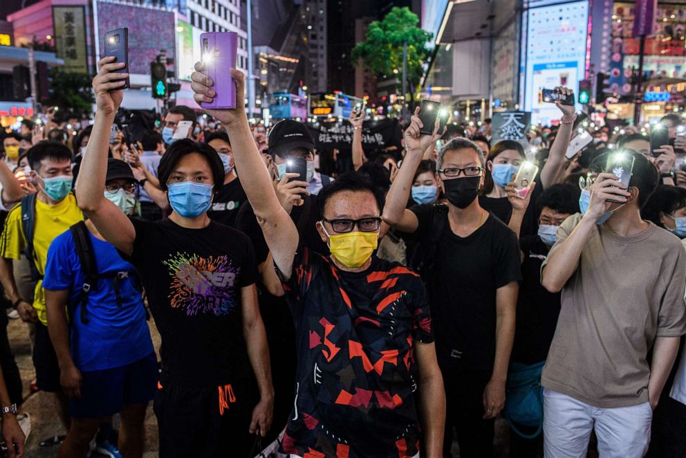 PHOTO: Pro-democracy activists hold up their mobile phone torches as they sing during a rally in the Causeway Bay district of Hong Kong on June 12, 2020.