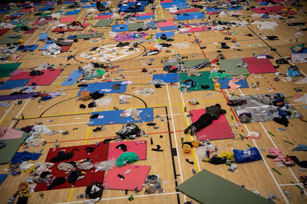 PHOTO: A man sleeps in a gym that is strewn with abandoned belongings at Hong Kong Polytechnic University, which has been taken over by anti-government protesters, on Nov. 21, 2019, in Hong Kong.