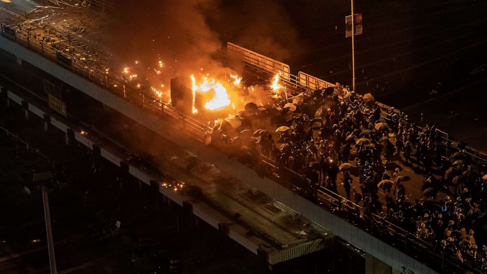 PHOTO: A police vehicle is set on fire as demonstrators throw fire bombs on a bridge at The Hong Kong Polytechnic University, Nov. 17, 2019, in Hong Kong.