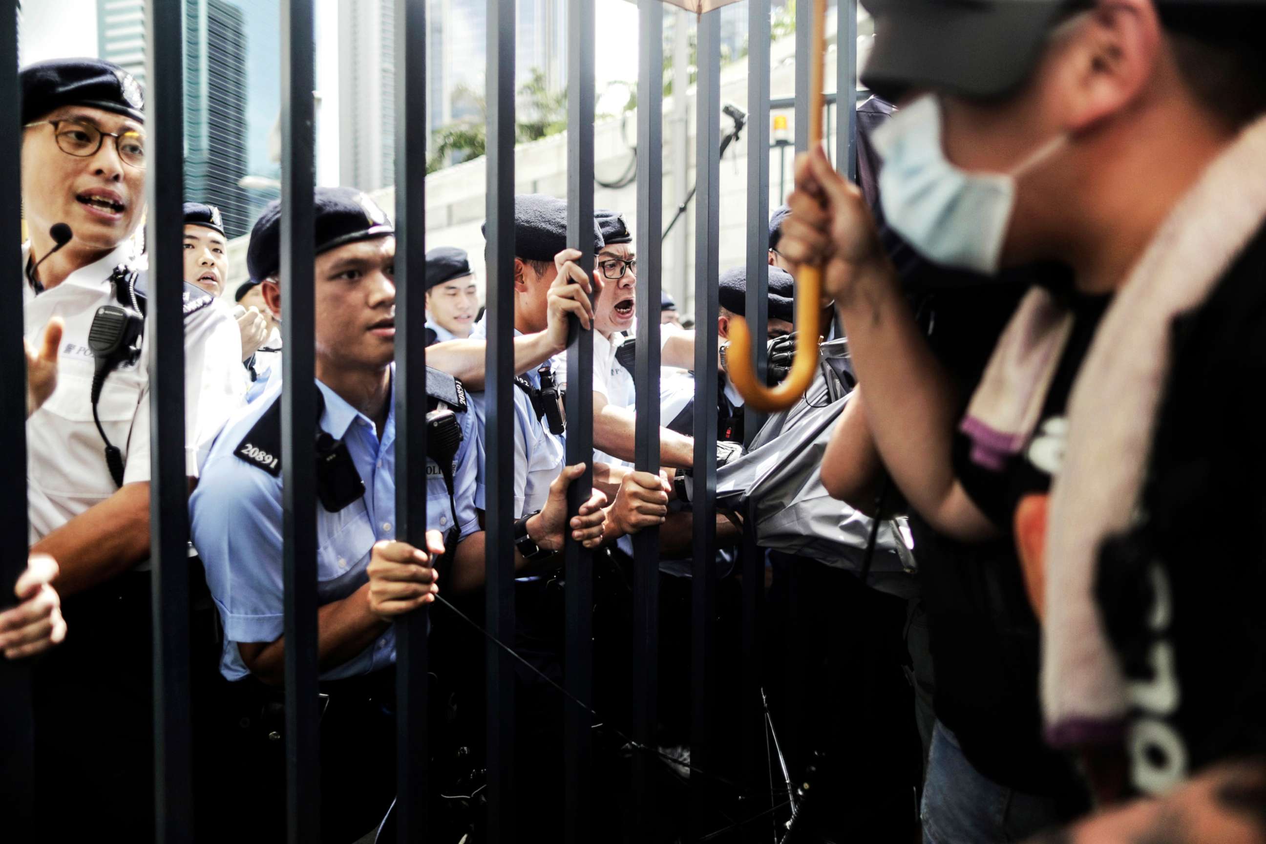 PHOTO: Police officers hold on to the gate as they block and argue with protesters who surrounded the police headquarters in Hong Kong, June 21, 2019. 