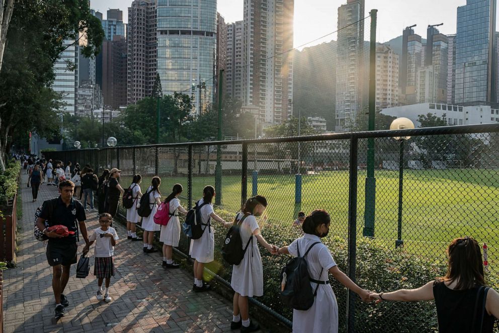 PHOTO: Students and alumni form a human chain outside a school, Sept. 9, 2019 in Hong Kong, in support of pro-democracy activists.
