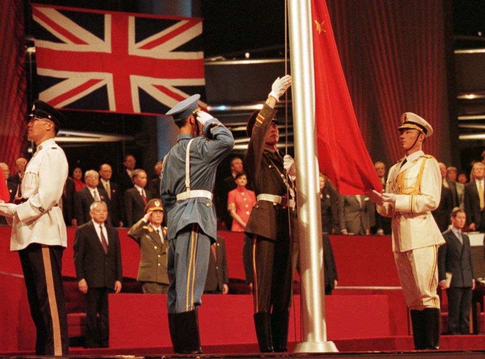 PHOTO: Members of the combined Chinese Armed Forces raise the Chinese Flag at the Hong Kong convention center on July 1, 1997 marking the moment Hong Kong reverted to Chinese rule.