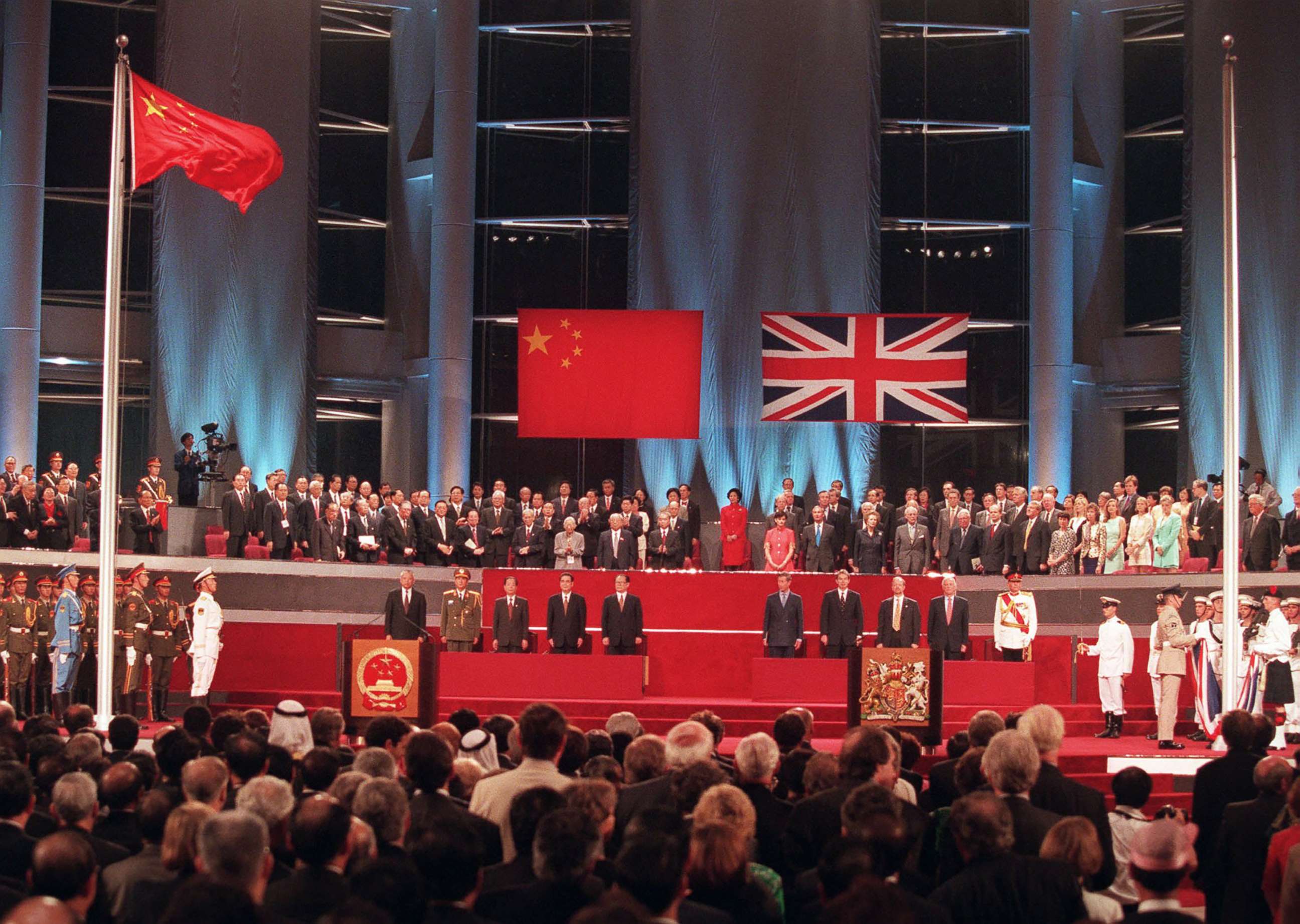 PHOTO: Officials participate in the handover ceremony, July 1, 1997, after the Chinese flag was raided (left) and the Union Jack was lowered.