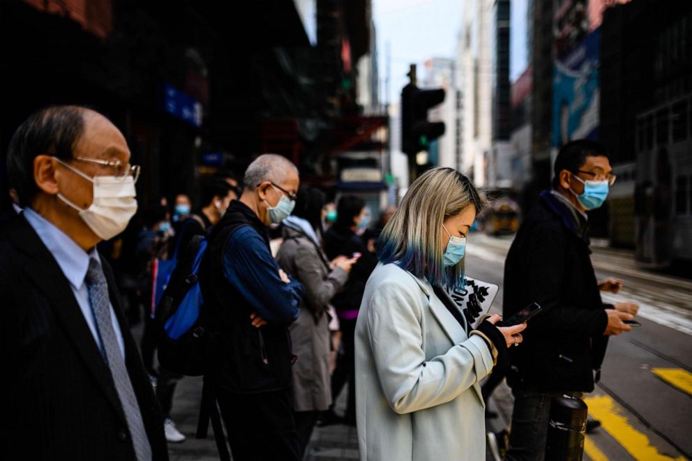 PHOTO: Pedestrians wear face masks as they walk on a footbridge in Hong Kong on Feb. 12, 2020.