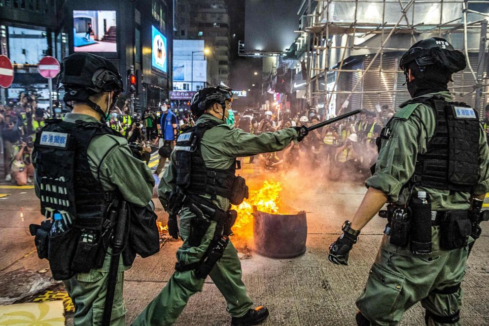 PHOTO: Police stand guard on a road to deter pro-democracy protesters from blocking roads in the Mong Kok district of Hong Kong on May 27, 2020, as the city's legislature debates over a law that bans insulting China's national anthem.