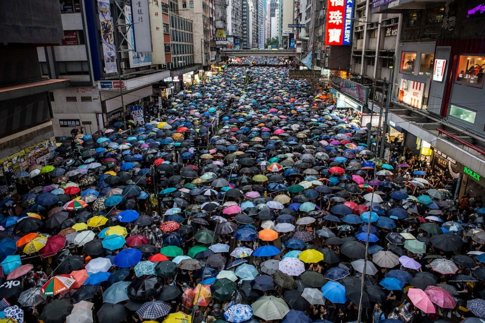 PHOTO: Pro-democracy protesters hold umbrellas while they walk down a street in Hong Kong on Aug. 18, 2019.