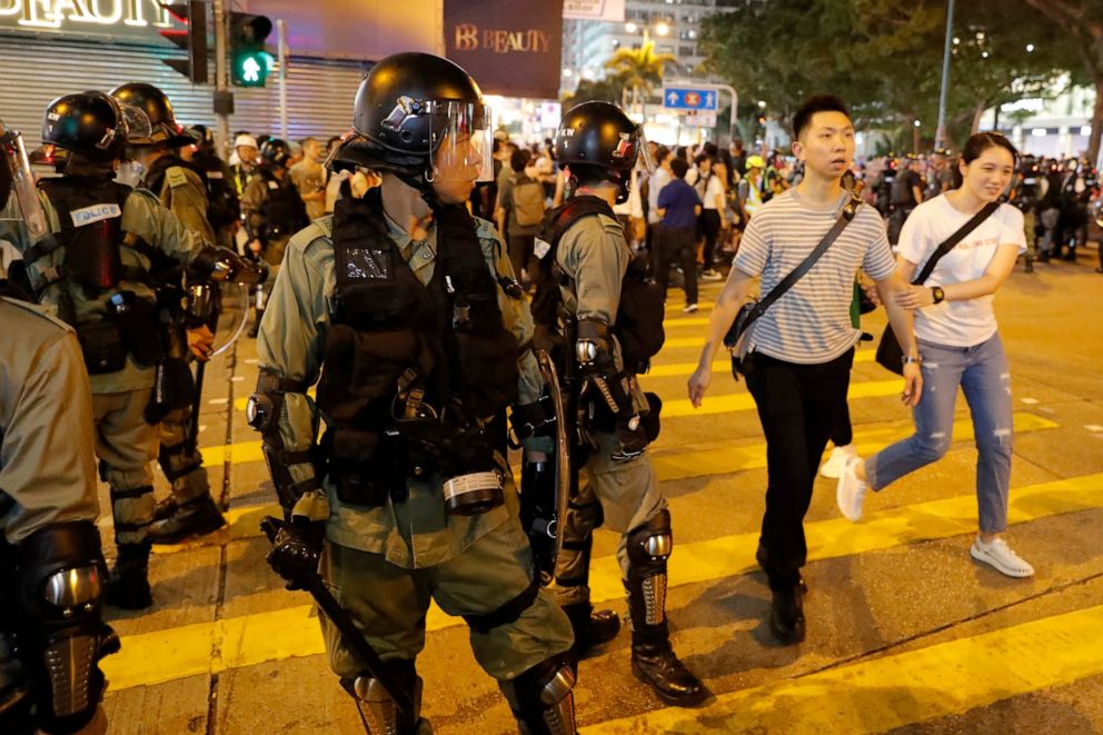 PHOTO: Residents past by police in riot gear during street protests in Hong Kong on Saturday, Aug. 10, 2019. 