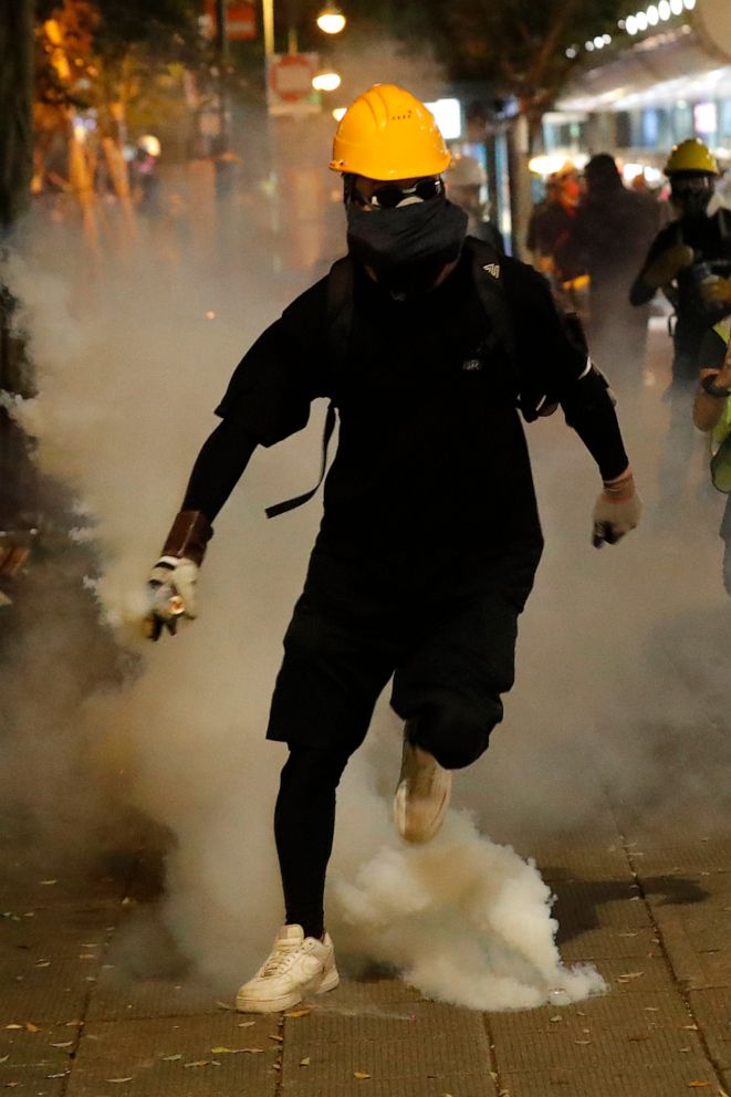 PHOTO: A protester prepares to throw back a tear gas canister fired near the Tsim Sha Tsui police station in Hong Kong on Saturday, Aug. 10, 2019. 