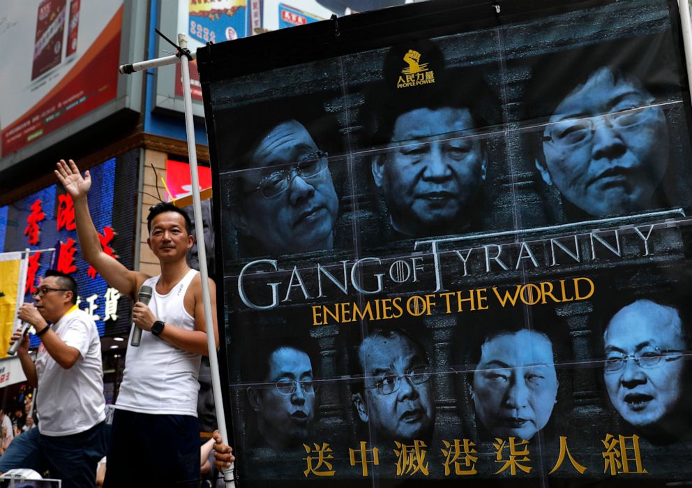 PHOTO: In this June 9, 2019, file photo, protesters display a banner with images of Chinese President Xi Jinping during a march along a downtown street against the proposed amendments to an extradition law in Hong Kong.