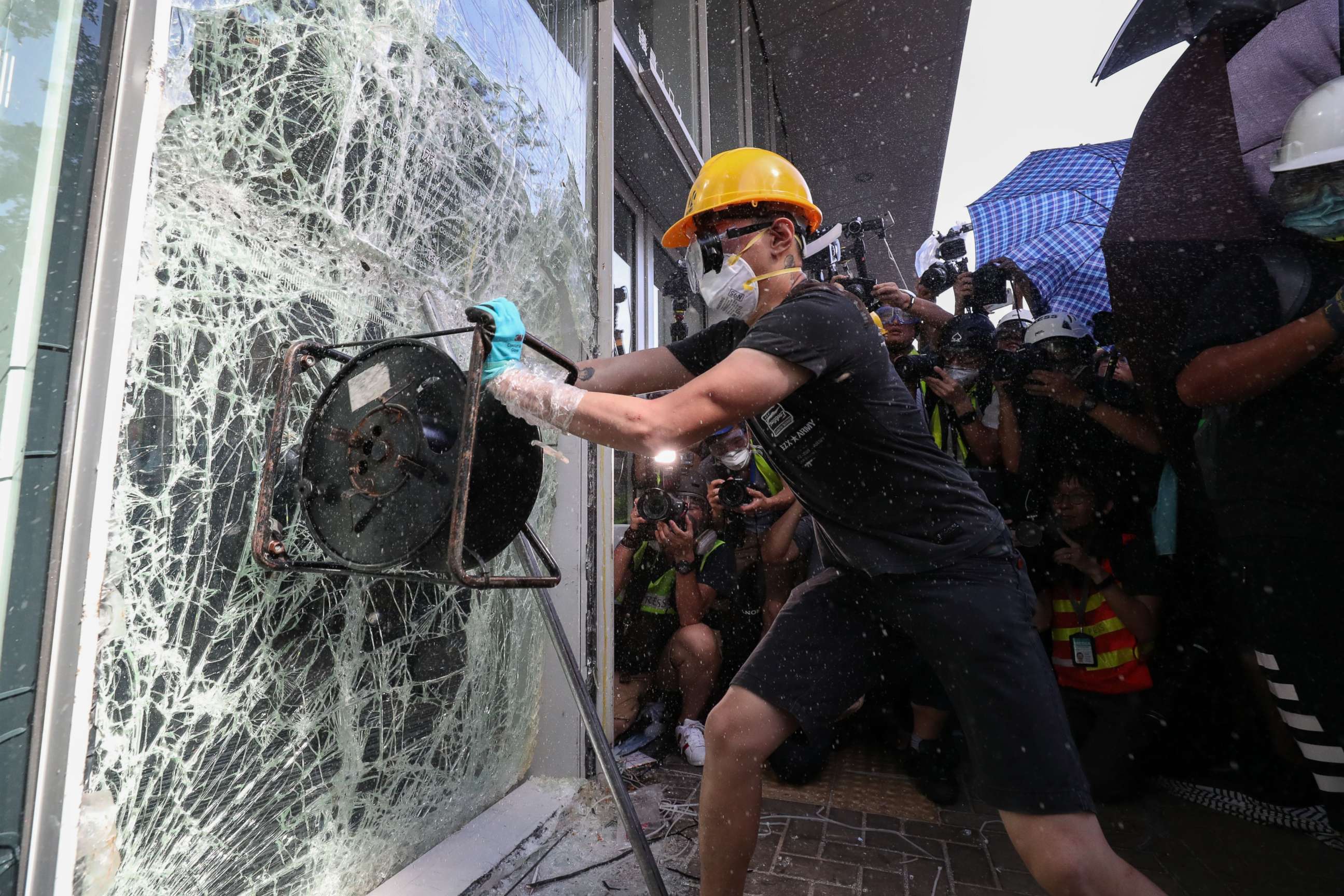 PHOTO: A protester breaks a window of the Legislative Council in Hong Kong, July 1, 2019.