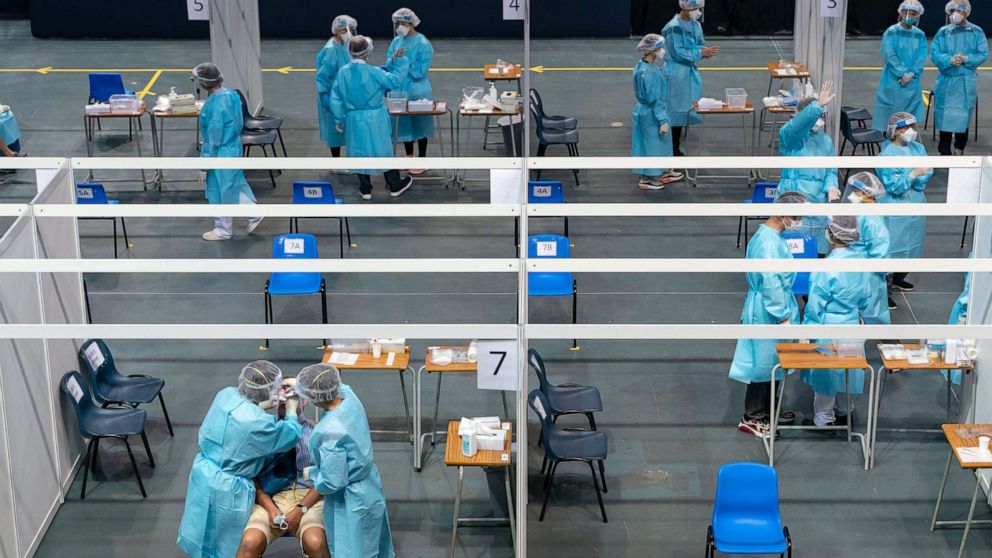 PHOTO: Healthcare professionals wearing personal protective equipment (PPE) conduct swab tests at a makeshift testing site in the Queen Elizabeth Stadium, Sept. 1, 2020 in Hong Kong.