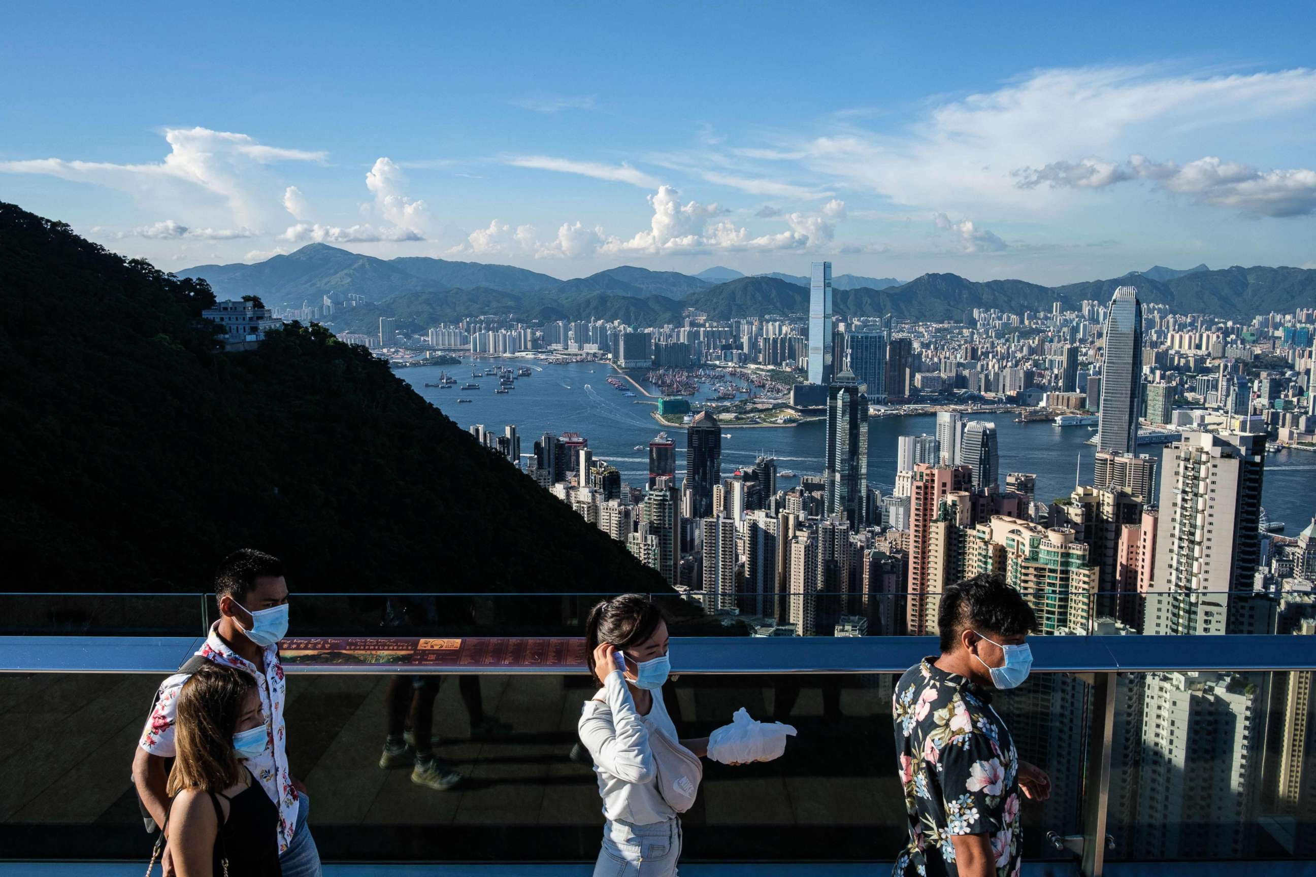 PHOTO: (FILES) In this file photo taken on July 28, 2020, visitors walk along a viewing platform on Victoria Peak in Hong Kong. - Hong Kong and Singapore announced on April 26, 2021 plans to resurrect their scrapped coronavirus travel bubble. 