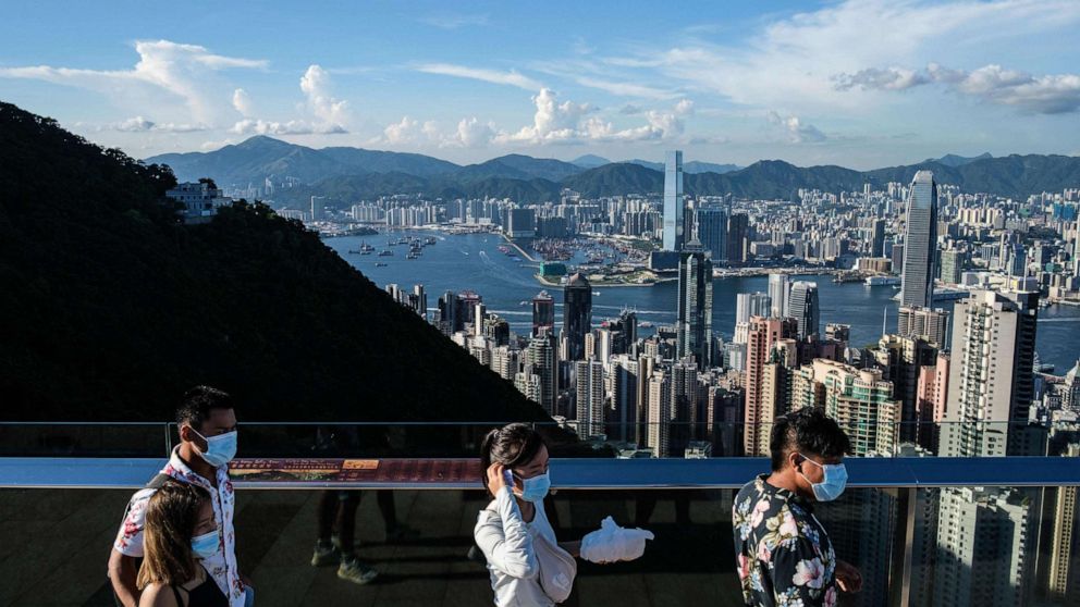 PHOTO: (FILES) In this file photo taken on July 28, 2020, visitors walk along a viewing platform on Victoria Peak in Hong Kong. - Hong Kong and Singapore announced on April 26, 2021 plans to resurrect their scrapped coronavirus travel bubble. 