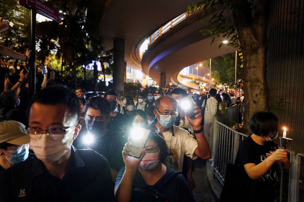 PHOTO: People flash lights from their mobile phones, as they walk on the road outside Victoria Park after police officers dispersed them on the 32nd anniversary of the crackdown at Beijing's Tiananmen Square in 1989, in Hong Kong, June 4, 2021.