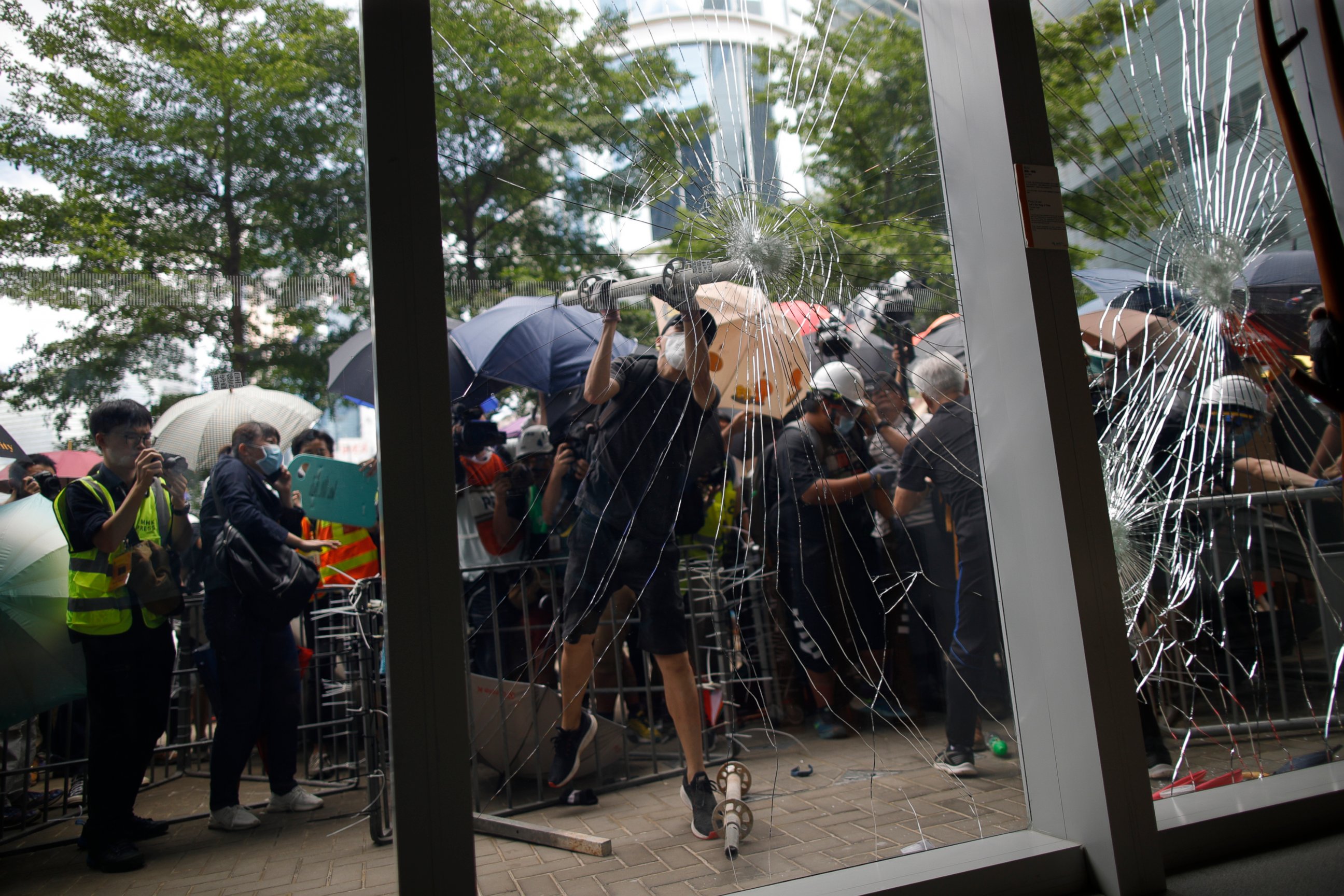 PHOTO: A protester tries to break the glass to get into the Legislative Council in Hong Kong Monday, July 1, 2019.