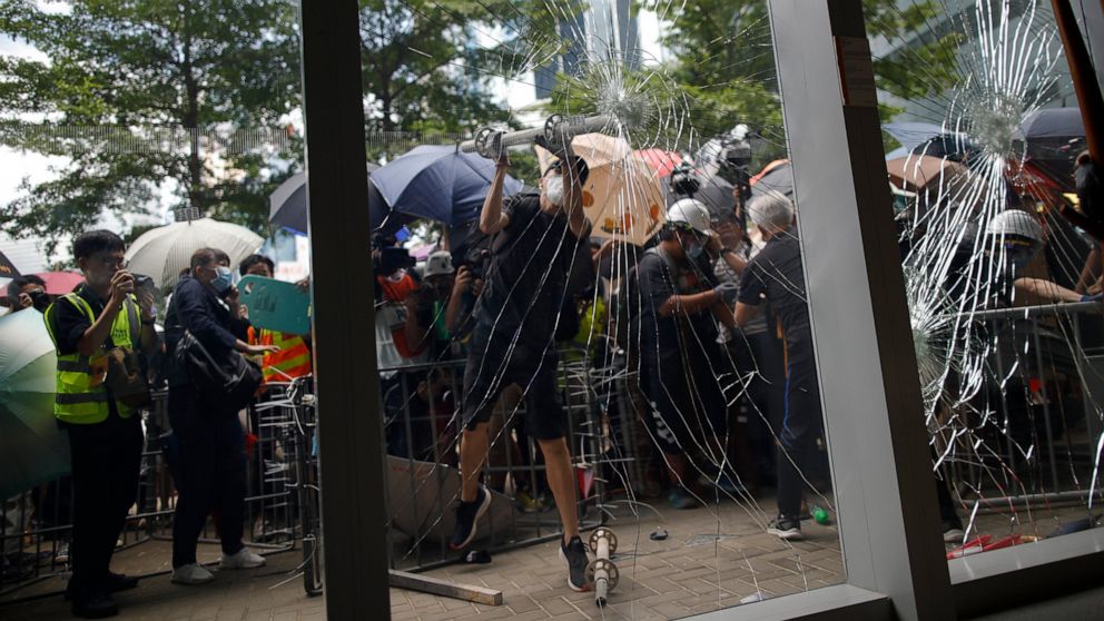PHOTO: A protester tries to break the glass to get into the Legislative Council in Hong Kong Monday, July 1, 2019.