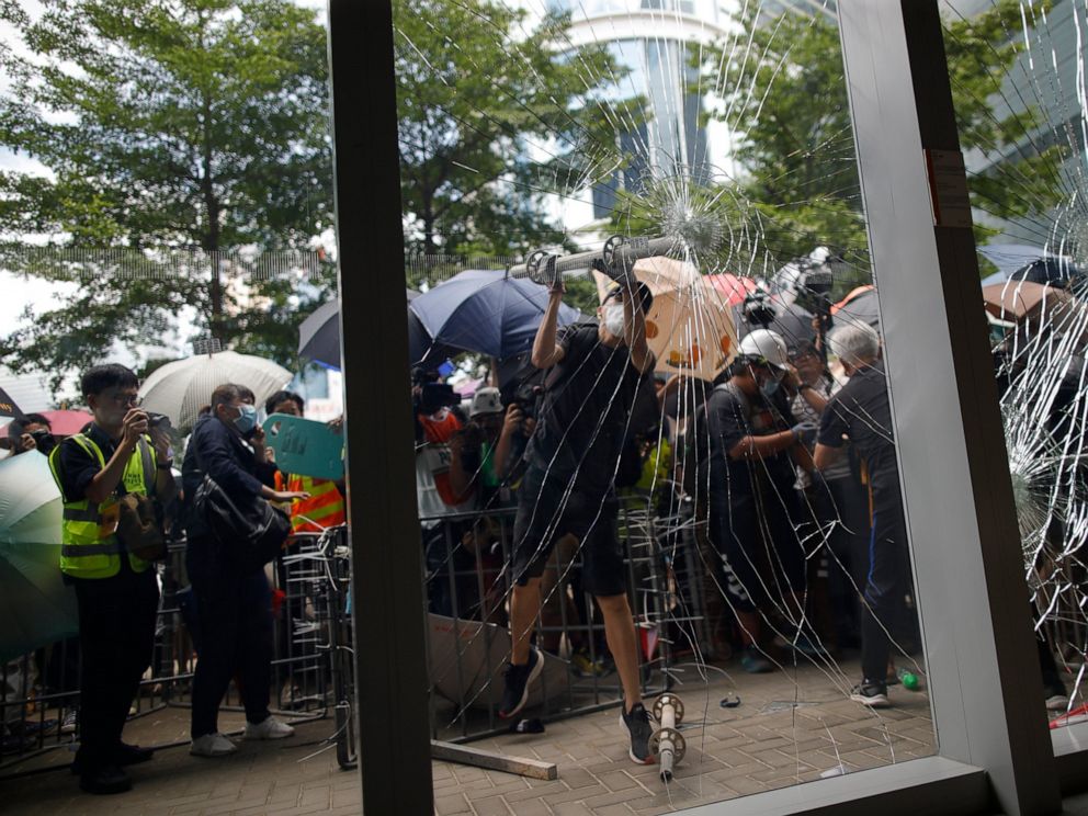 PHOTO: A protester tries to break the glass to get into the Legislative Council in Hong Kong Monday, July 1, 2019.