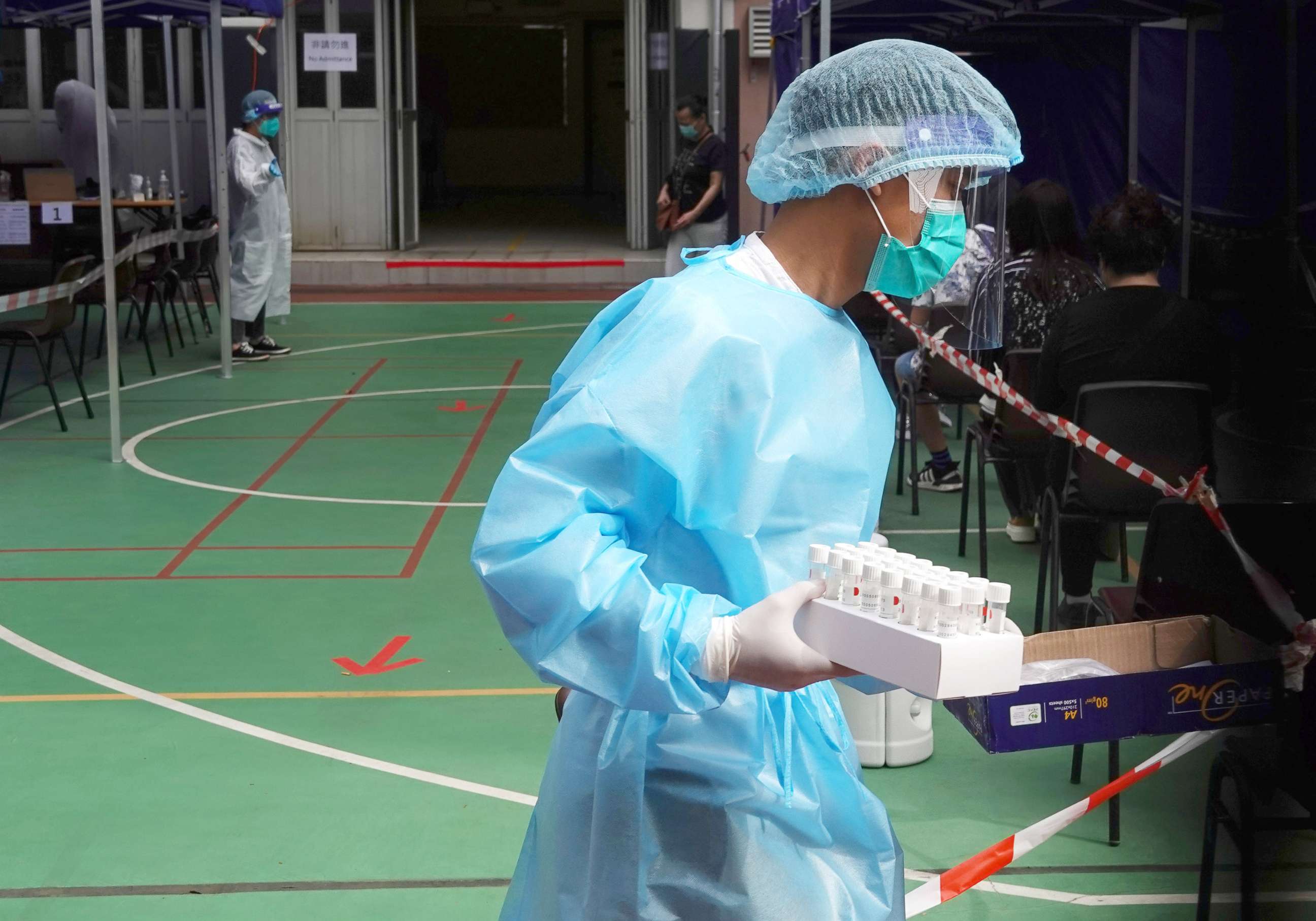 PHOTO: A medical worker in protective suit carries test tubes at a community testing center for the coronavirus disease in Hong Kong's Yau Tsim Mong district, China, Nov. 24, 2020.