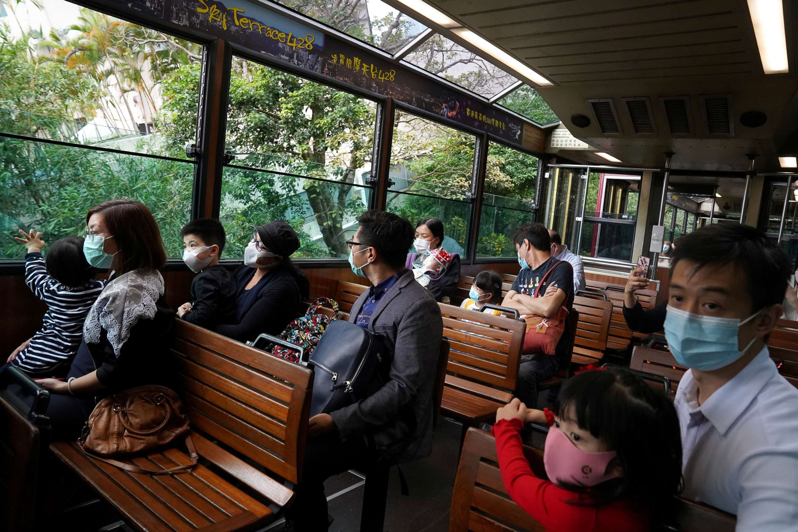 PHOTO: Visitors wearing face masks following the coronavirus disease outbreak  look at the view from inside the Peak tram in Hong Kong, China, Nov. 10, 2020.