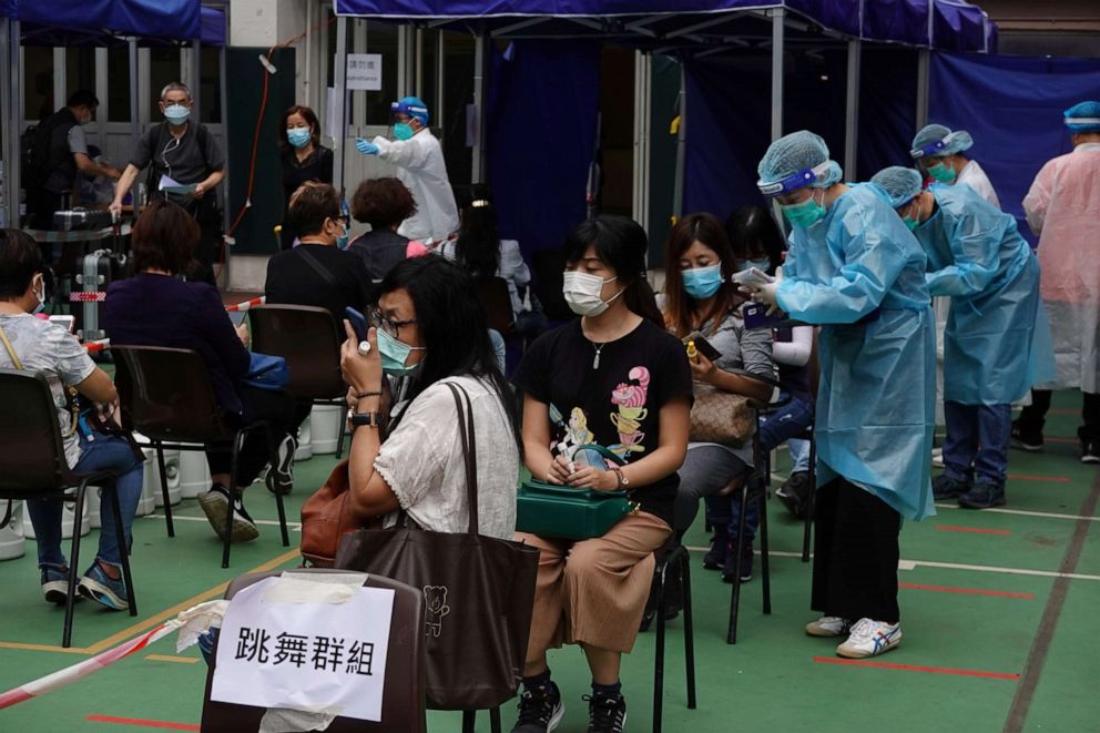 PHOTO: Medical workers in protective suits attend to people at a community testing center for the coronavirus disease in Hong Kong's Yau Tsim Mong district, China, Nov. 24, 2020.