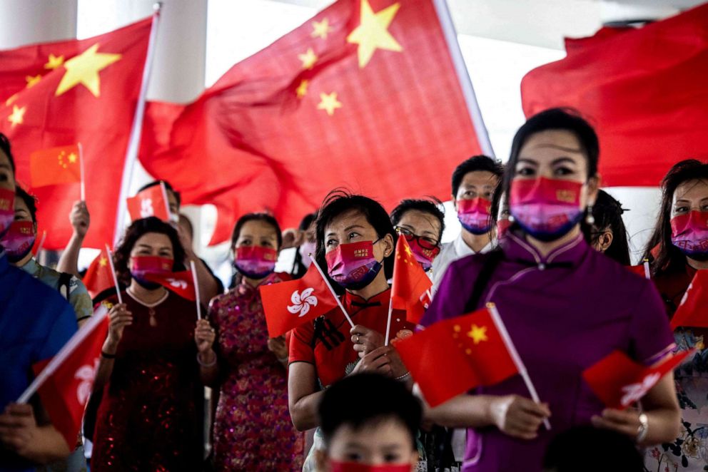 PHOTO: People hold the Hong Kong and Chinese flags while singing to celebrate the 25th anniversary of the city's handover from Britain to China, in Hong Kong on July 1, 2022.