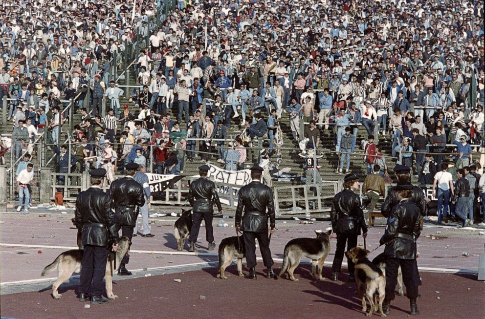 PHOTO: Belgium policemen with dogs face Italian fans, on May 29, 1985 in Heysel stadium in Brussels