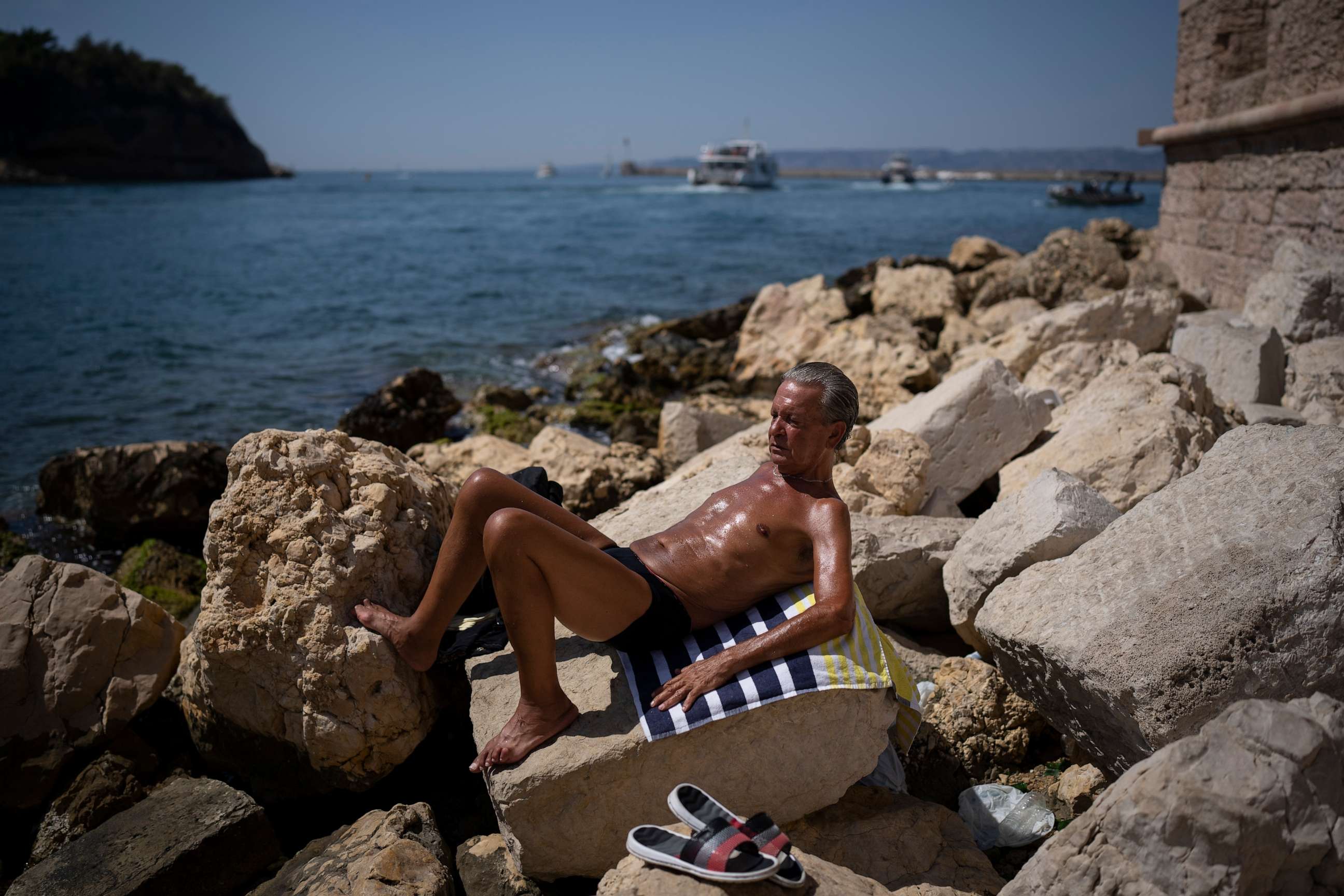 PHOTO: FILE - A man sunbathes in high temperatures in Marseille, southern France, Aug. 19, 2023. UN weather agency says Earth sweltered through the hottest summer ever as record heat in August capped a brutal, deadly three months in northern hemisphere.