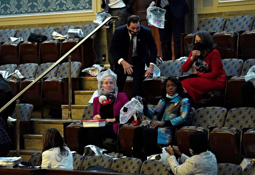 PHOTO: People wear plastic bags protesters attempt to enter the House Chamber during a joint session of Congress on Jan. 06, 2021, in Washington, D.C.