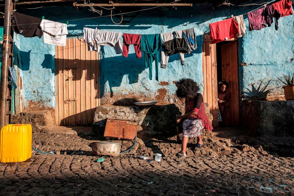 PHOTO: A woman sits in front of a house in the northern city of Gondar in Ethiopia's Amhara region on Nov. 9, 2020.