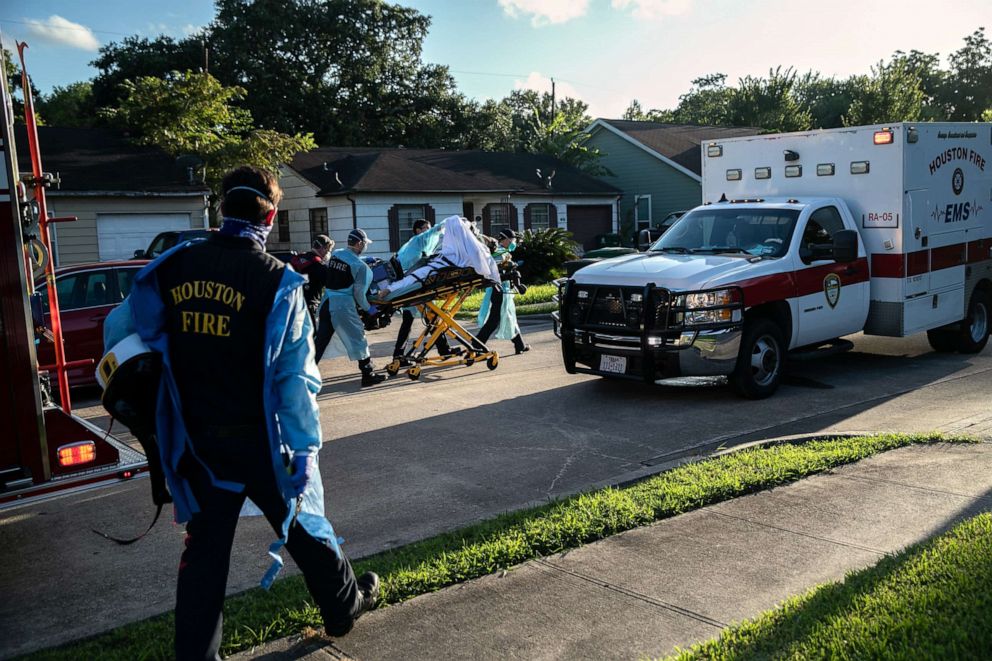PHOTO: Houston Fire Department EMS medics transport a man with possible COVID-19 symptoms to a hospital, on Aug. 10, 2020, in Houston.
