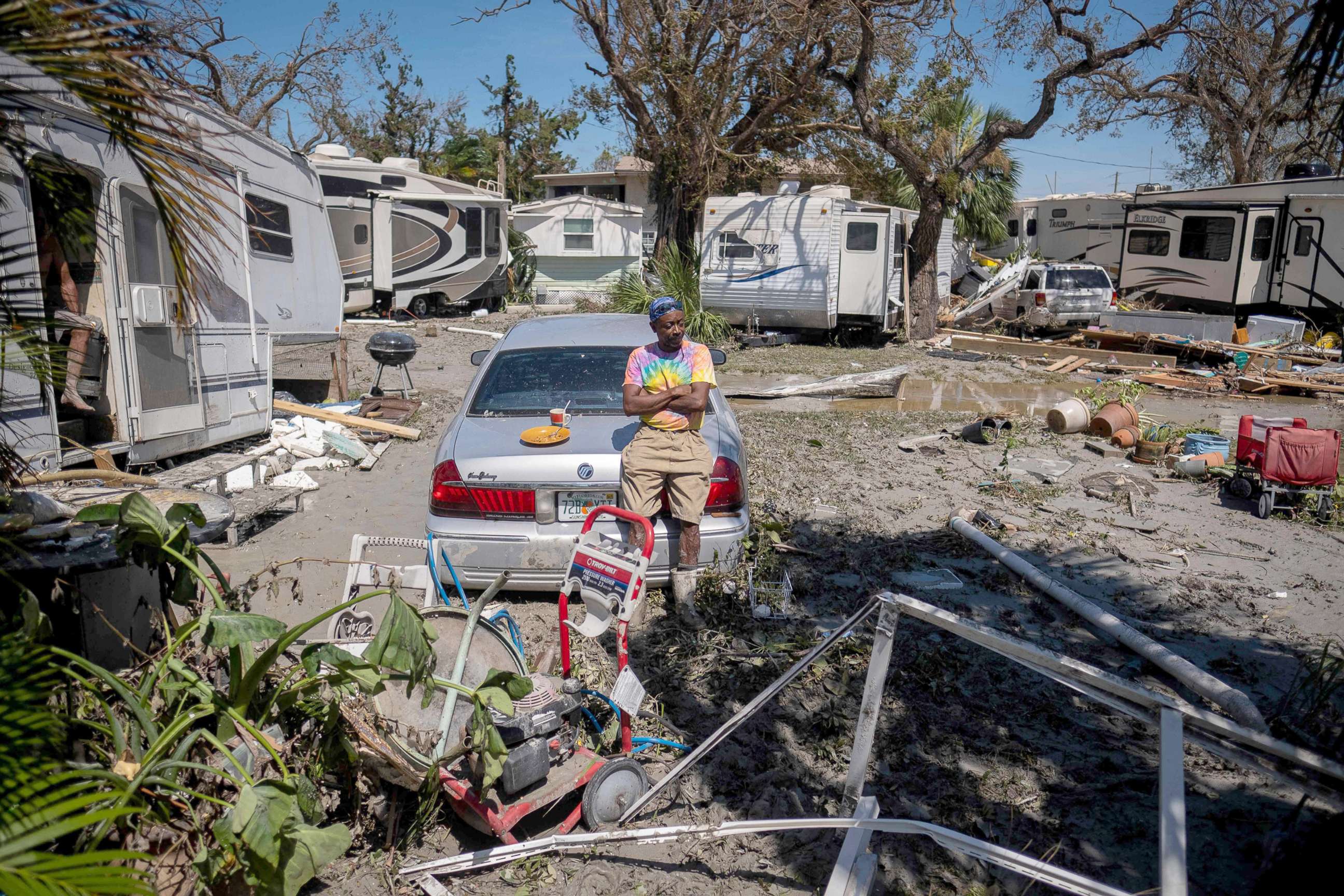 PHOTO: Sean Hunt sings on the trunk of his damaged car in front of his camper in the aftermath of Hurricane Ian in Fort Myers, Fla., Sept. 29, 2022.
