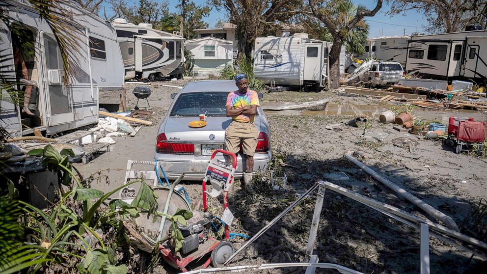 PHOTO: Sean Hunt sings on the trunk of his damaged car in front of his camper in the aftermath of Hurricane Ian in Fort Myers, Fla., Sept. 29, 2022.