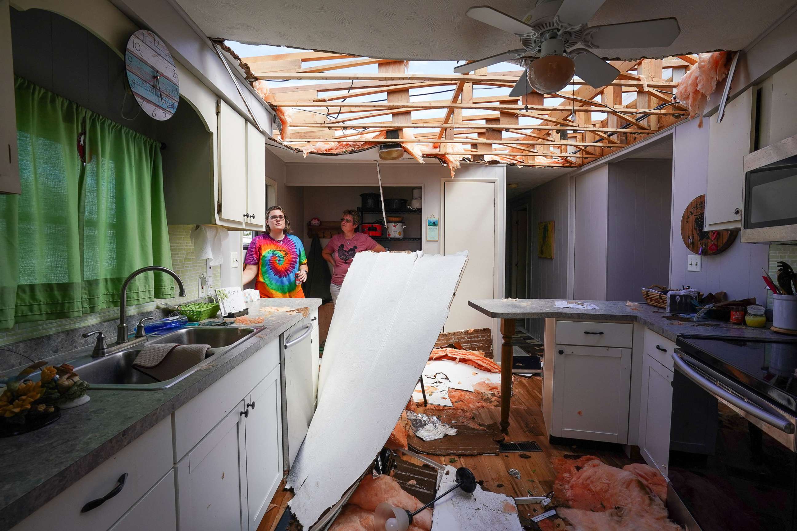 PHOTO: Andrea Barrios and her daughter Hannah look over the damaged home of her father in an effort to salvage personal belongings in the aftermath of Hurricane Ian in Charlotte Harbor, Fla.,  Sept. 29, 2022.