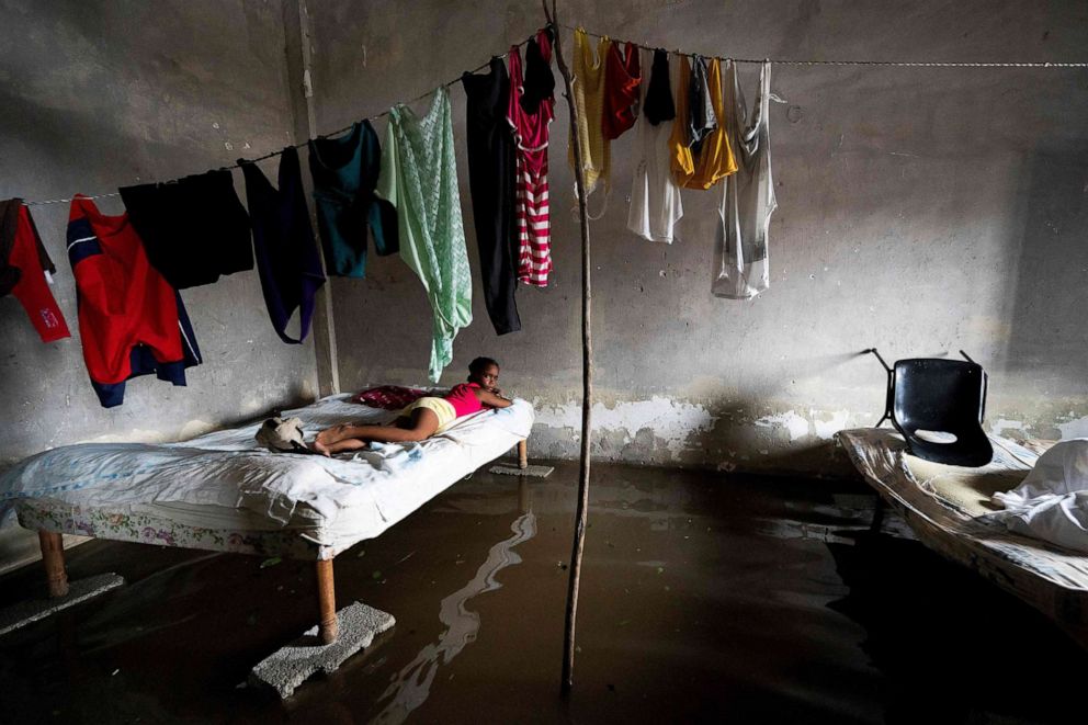 PHOTO: A girl lies on a bed at her flooded home during the passage of hurricane Ian in Batabano, Cuba, Sept. 27, 2022. 