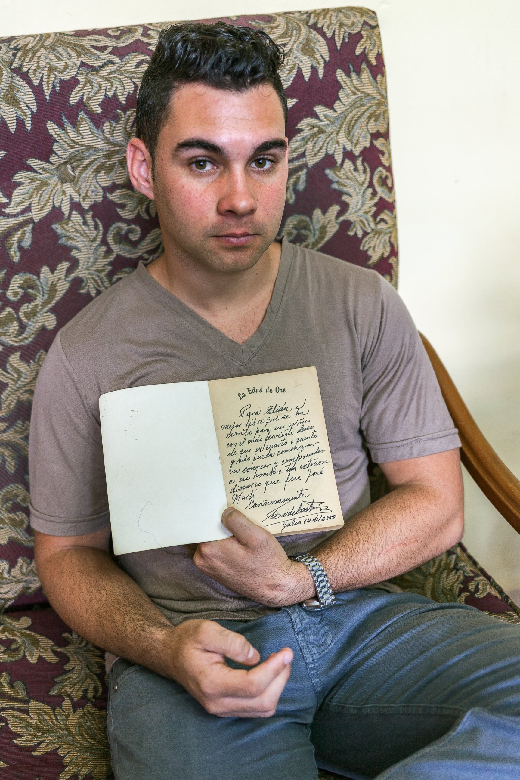 PHOTO: Elian Gonzalez holds a copy of "La Edad de Oro" by Jose Marti, given to him and signed by Fidel Castro, July 2000.