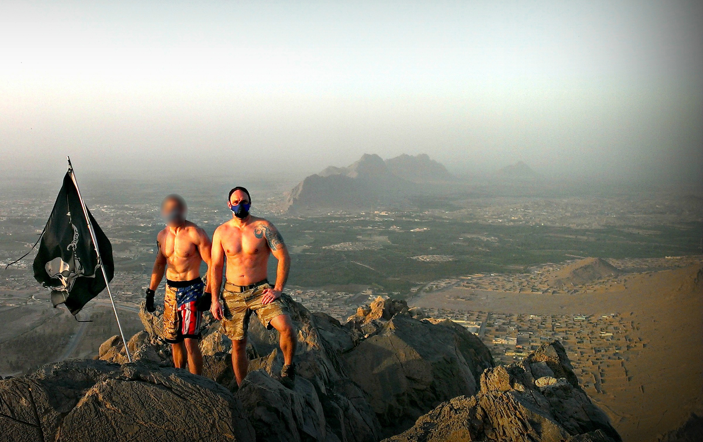 PHOTO: Brett Jones stands with a colleague on a mountaintop during a recent deployment abroad.