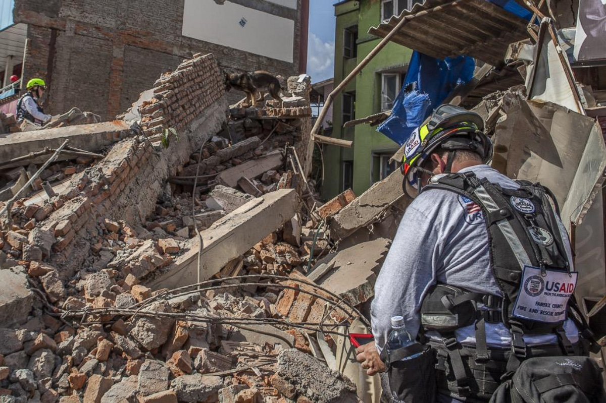 PHOTO: Members of a USAID Dart canine team work to find people trapped under a building that collapsed in Naya Bazaar, Nepal after an earthquake hit on May 12, 2015. 
