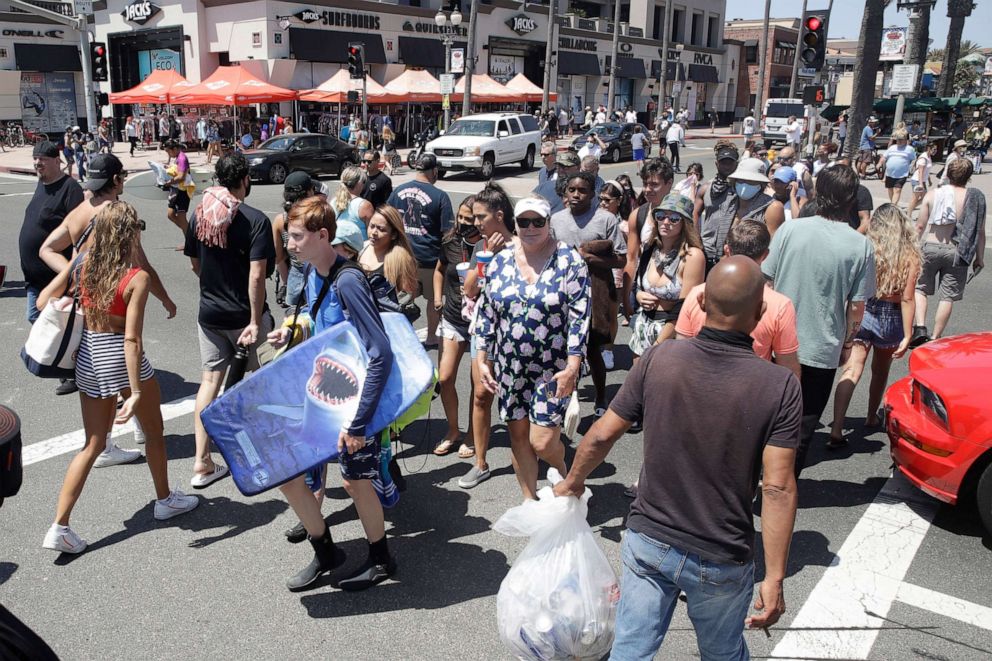 PHOTO: Beach goers cross the Pacific Coast Highway in Huntington Beach, Calif., June 27, 2020.