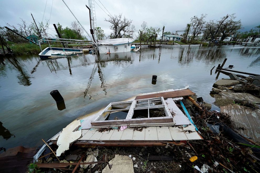 PHOTO: An oil sheen drifts between a sunken shrimp boat and pieces of a destroyed home along Bayou Pointe au Chien in the aftermath of Hurricane Ida in Pointe-aux-Chenes, La., Sept. 14, 2021.