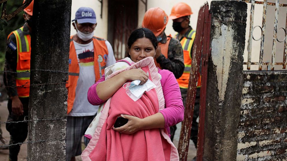 PHOTO: A woman carrying her son leaves her house as Honduran soldiers evacuate residents in anticipation of heavy rains as Hurricane Iota approaches, in Marcovia, Honduras, Nov. 17, 2020.